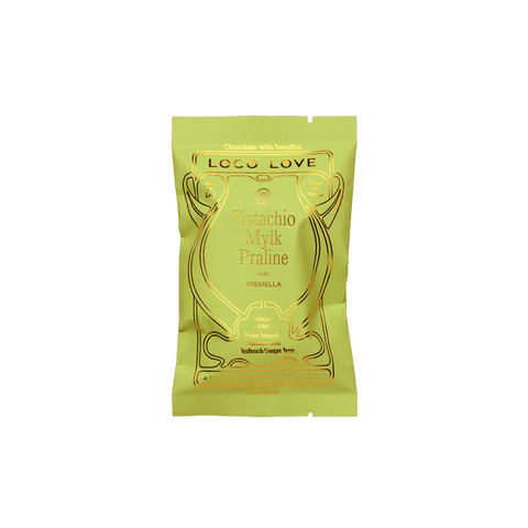 A single packet of Logo Love Pistachio Mylk Praline chocolates with vanilla, in a light yellow-green packaging with gold foil lettering, centered on a plain white background.
