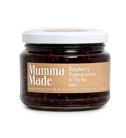 A glass jar of Mumma Made Raspberry Pomegranate & Thyme Jam with a white lid and a tan label, shown on a plain white background.