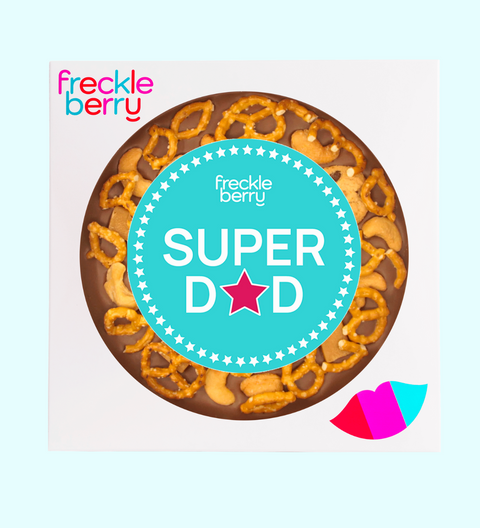 A fun giant Belgian milk chocolate pizza topped with pretzels, chocolate chip cookies, caramel fudge, and salted cashews with "Super Dad" sticker, the perfect festive treat to celebrate Father's Day.