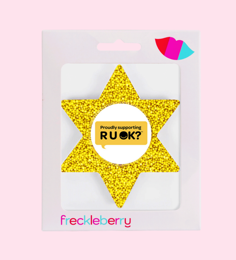 Yellow star-shaped object with a white center displaying 'Proudly supporting RUOK?' on a pink background.