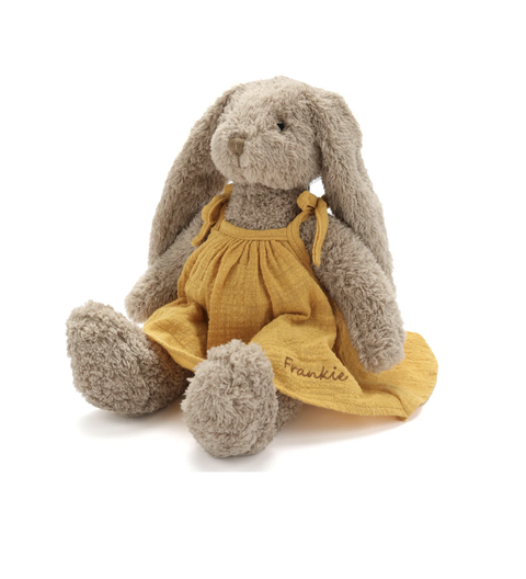 Plush bunny toy with a mustard yellow dress on a white background