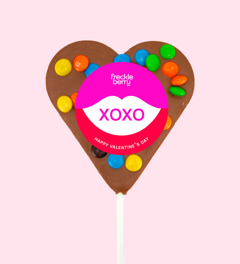 Creamy Belgian milk chocolate heart pop topped with colourful M&M®s with "XOXO" label/design - a sweet way to share the love.