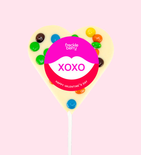 Creamy Belgian white chocolate heart pop topped with colourful M&M®s with "XOXO" label/design - a sweet way to share the love.