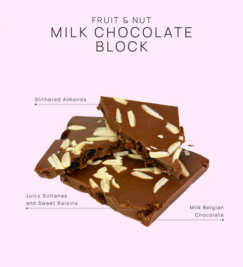 Fruit and nut milk chocolate block with visible ingredients on a light pink background
