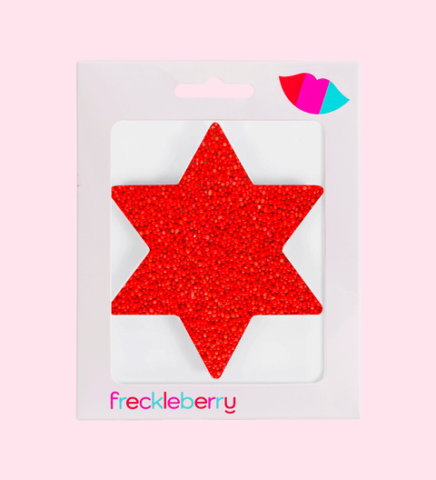 Red star-shaped object in packaging with 'freckleberry' branding on a pink background. Luna New Year Gifts