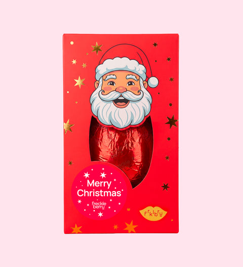 A festive red chocolate bar in a rectangular gift box featuring a cartoon Santa face and gold star accents, with a round red sticker that reads 'Merry Christmas' and a small yellow 'feetfeet' logo near the bottom.