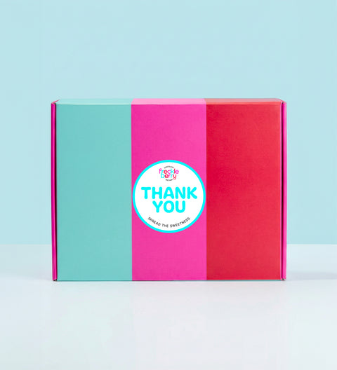 Colorful hamper gift box with a 'Thank You' sticker on a light blue background
