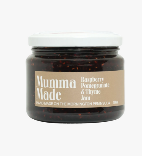 Jar of raspberry pomegranate thyme jam with 'Mumma Made' label on a white background