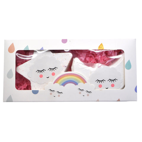 A box containing two bath bombs, one shaped like a moon and the other like a star, both with sleeping eyes and a rainbow across the moon shape. The box is decorated with raindrop and colorful polka dot designs.
